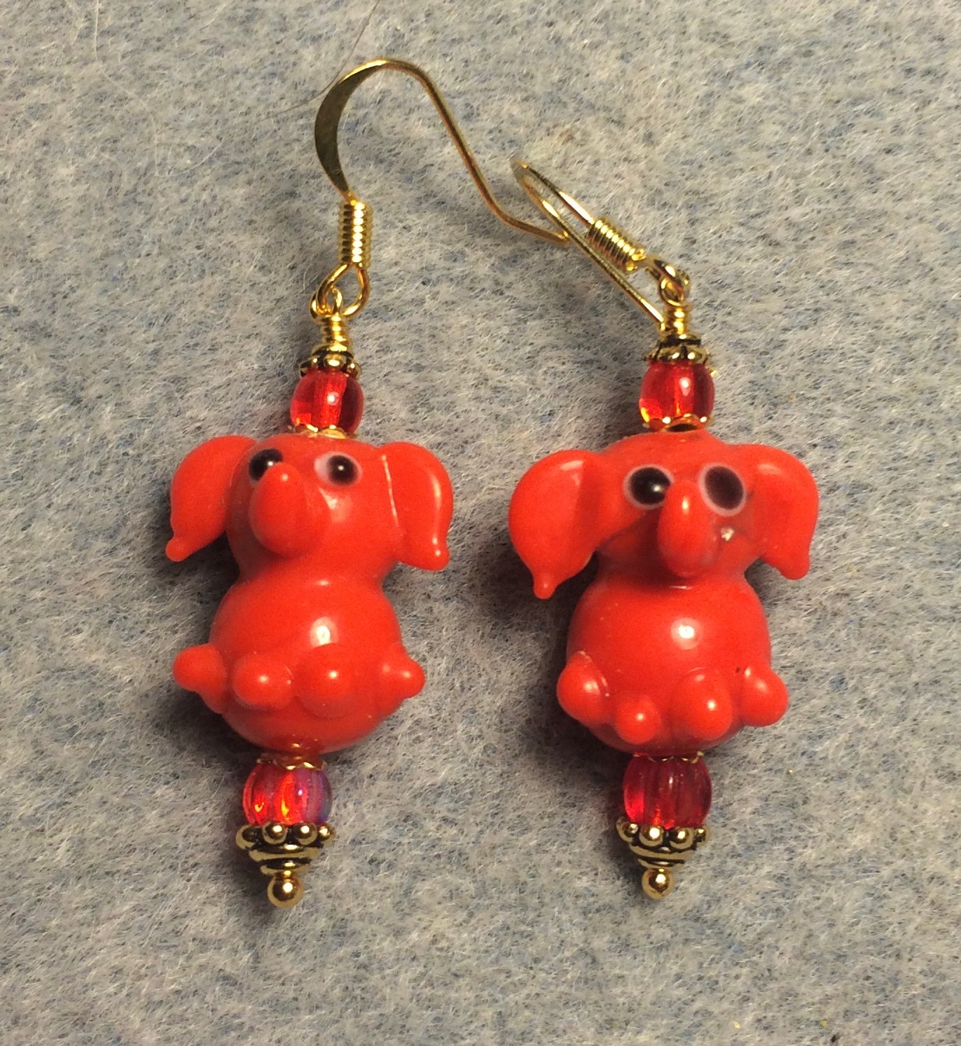 Opaque bright red lamp work sitting elephant bead earrings adorned with red Czech glass beads.