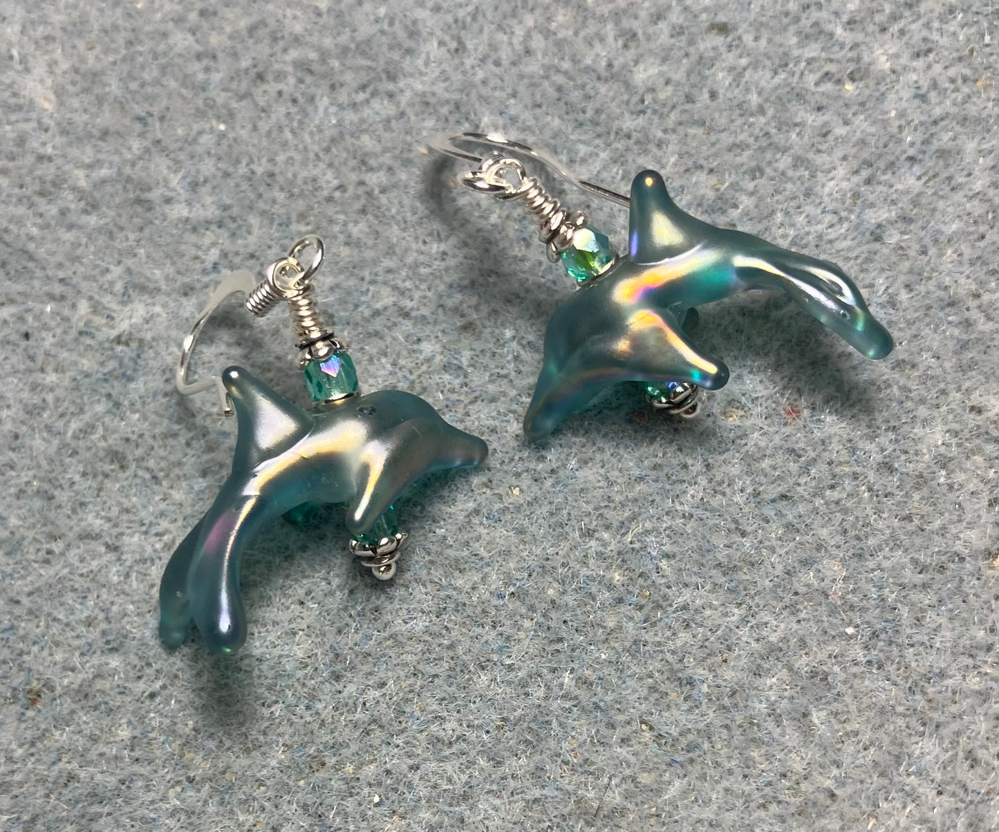 Tiny matte teal lamp work dolphin bead earrings adorned with tiny teal Chinese crystal beads.