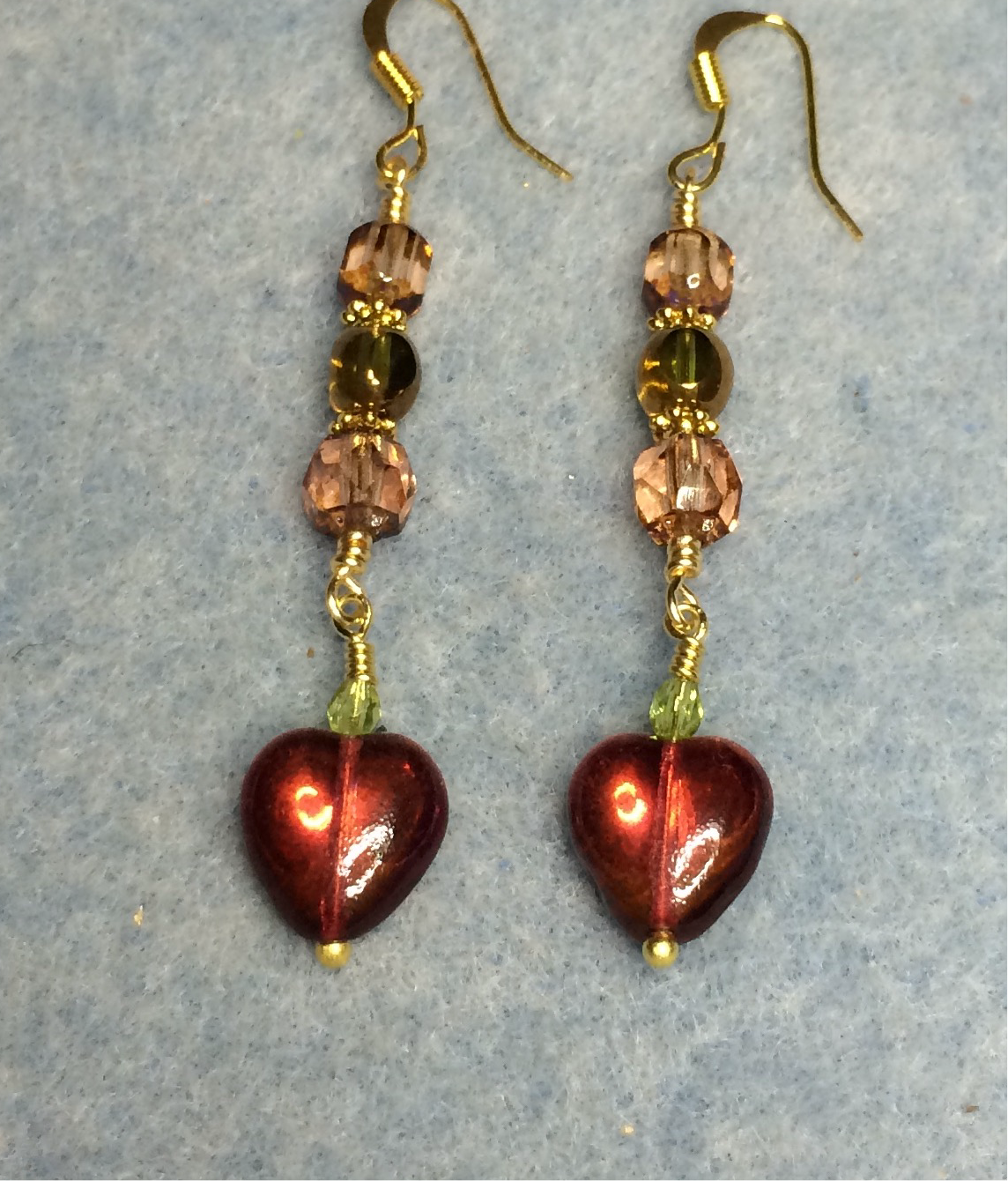 Small burnt orange and olive green Czech glass heart bead earrings adorned with rosaline and olive green Czech glass beads.