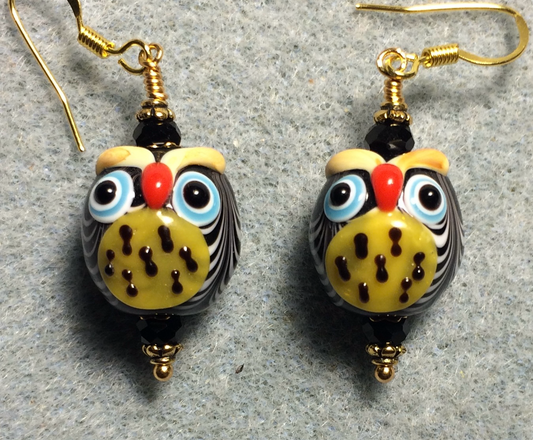 Black and yellow lamp work spotted owl bead earrings adorned with black Chinese crystal beads.