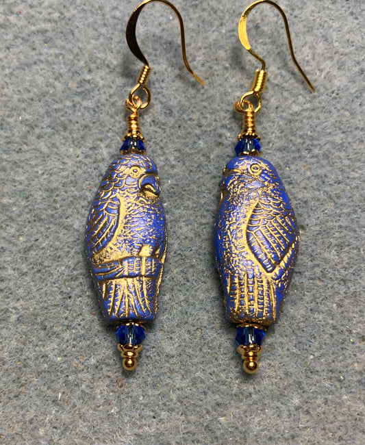 Large blue (with gold wash) Czech glass parrot bead earrings adorned with blue Chinese crystal beads.