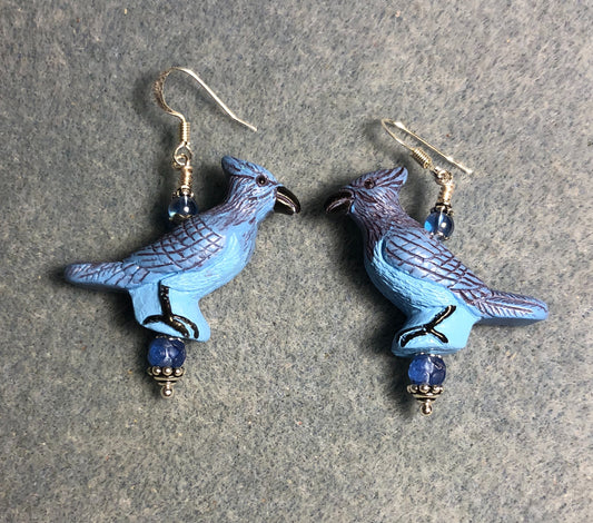 Large blue ceramic blue jay bead earrings adorned with blue Czech glass beads.