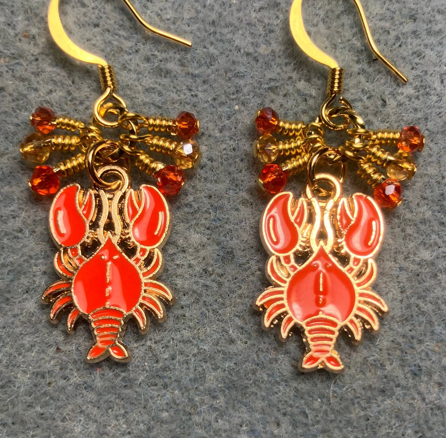 Orange enamel lobster charm earrings adorned with tiny dangling orange and amber Chinese crystal beads.