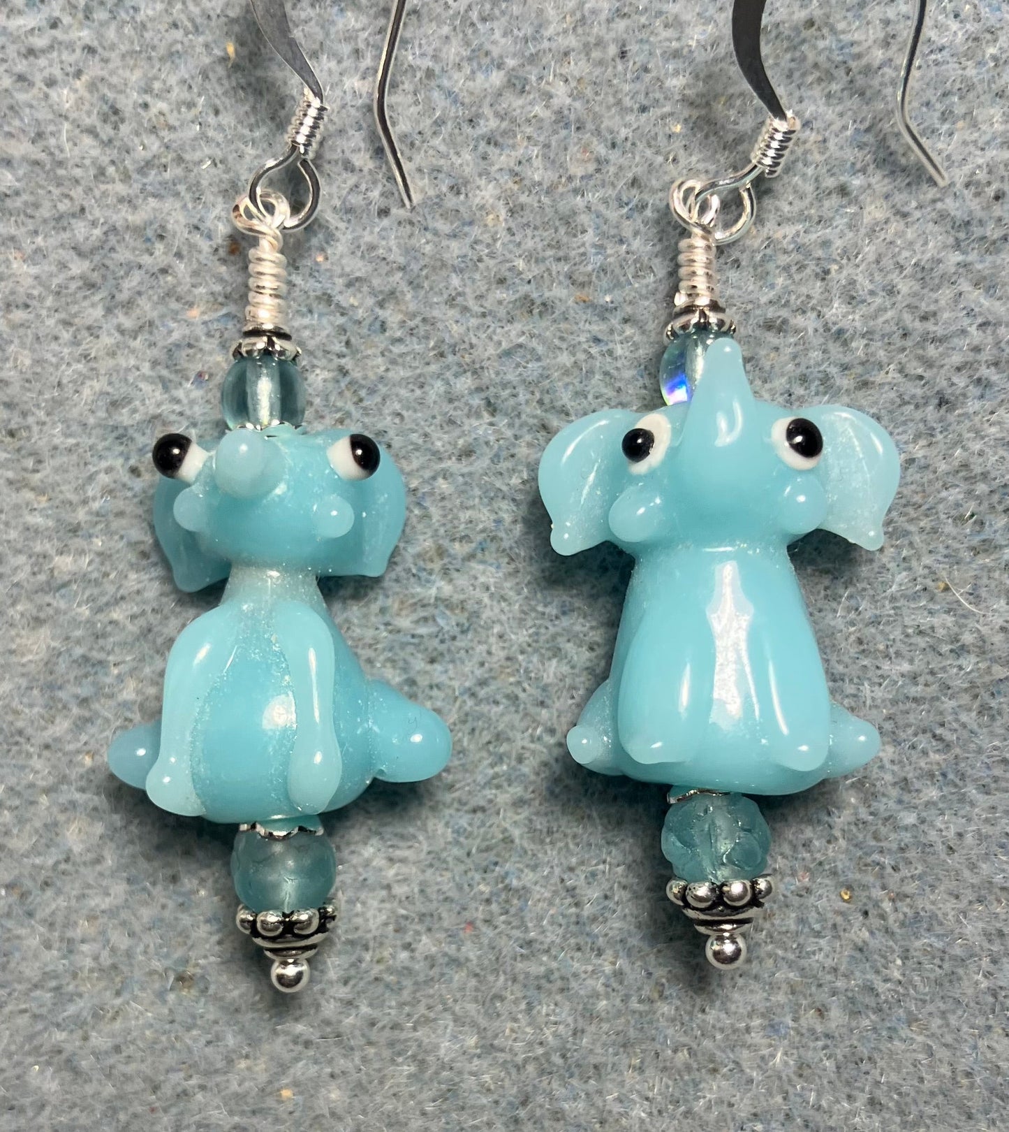 Opaque light aqua lamp work sitting elephant bead earrings adorned with light aqua Czech glass beads.