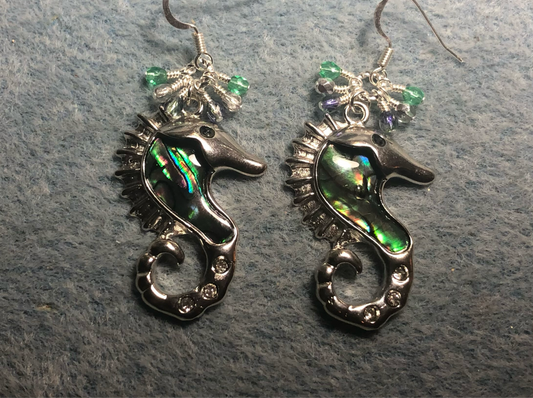 Silver, abalone, and rhinestone seahorse charm earrings adorned with small dangling light green, silver, and violet Czech glass beads.