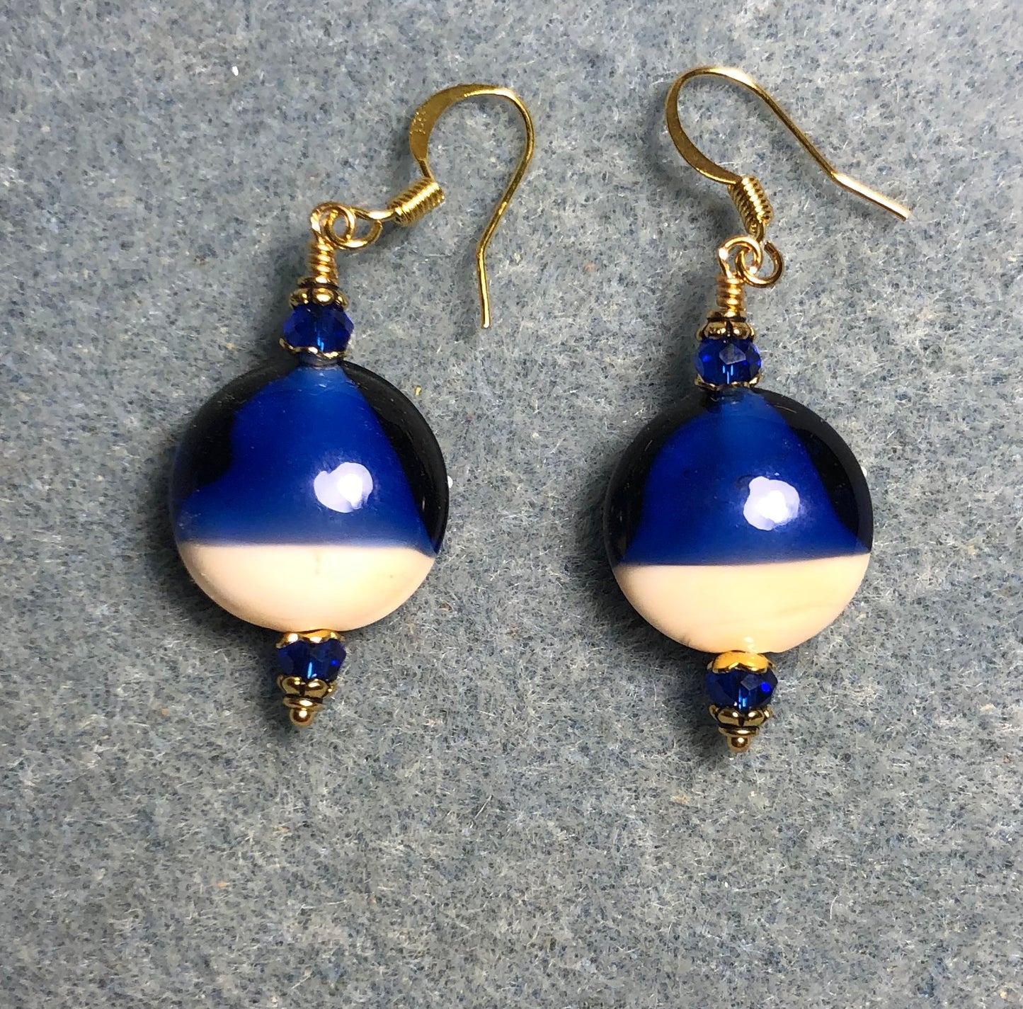 Dark blue, red, and tan lamp work starfish bead earrings adorned with dark blue Chinese crystal beads.