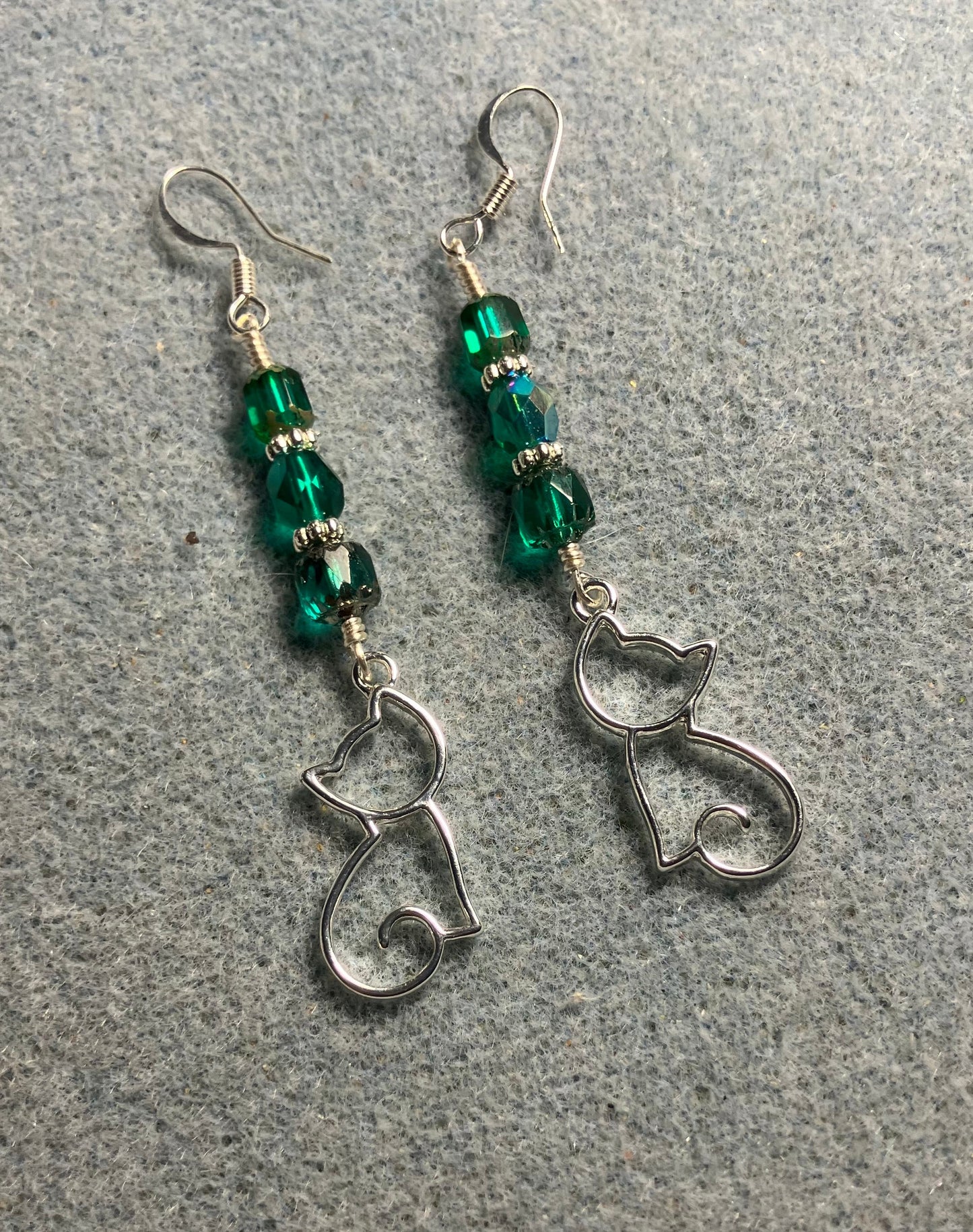 Silver silhouette cat charm earrings adorned with teal Czech glass beads.