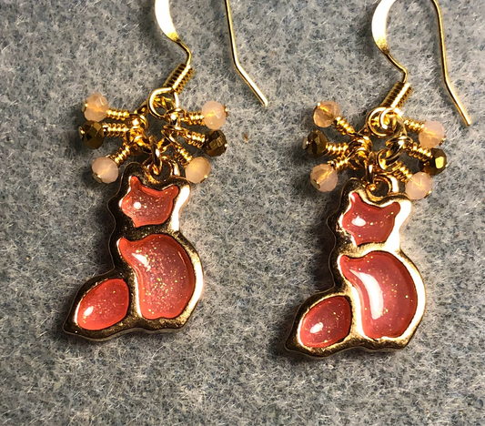 Pinkish peach and gold sparkly resin cat charm earrings adorned with small dangling peach, gold, and pink Chinese crystal beads.