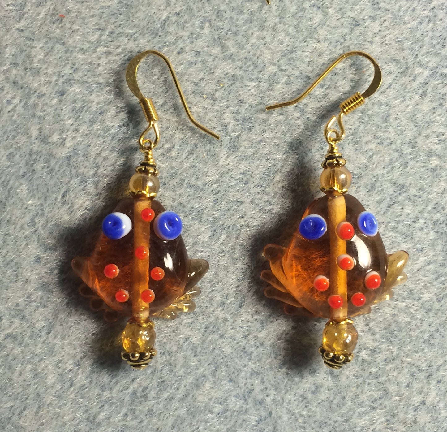 Transparent amber lamp work frog bead earrings adorned with amber Czech glass beads.