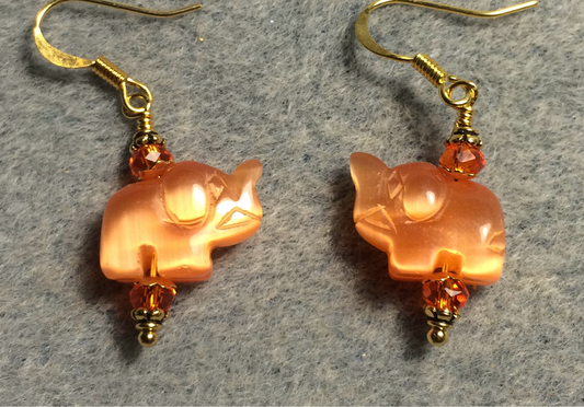 Small orange fiber optic (cat’s eye) elephant bead earrings adorned with orange Chinese crystal beads.