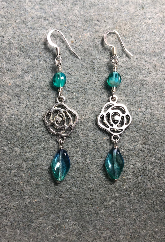 Silver rose connector charm earrings adorned with blue green Czech glass twist beads and blue green Czech glass beads.