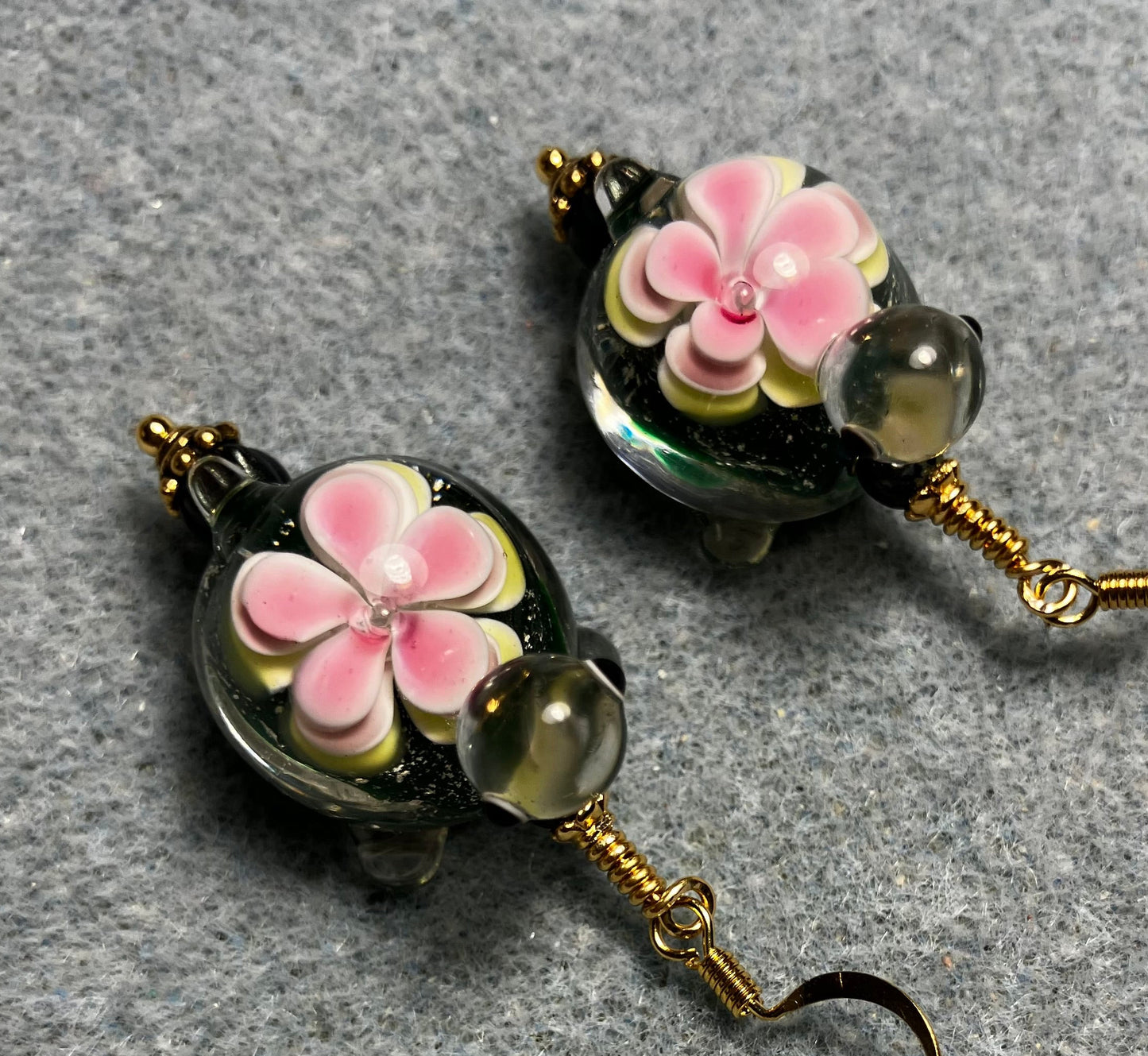 Large dark green and pink lamp work turtle bead earrings adorned with dark green Czech glass beads.