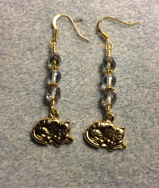 Gold sleeping cat charm earrings adorned with light blue Czech glass beads