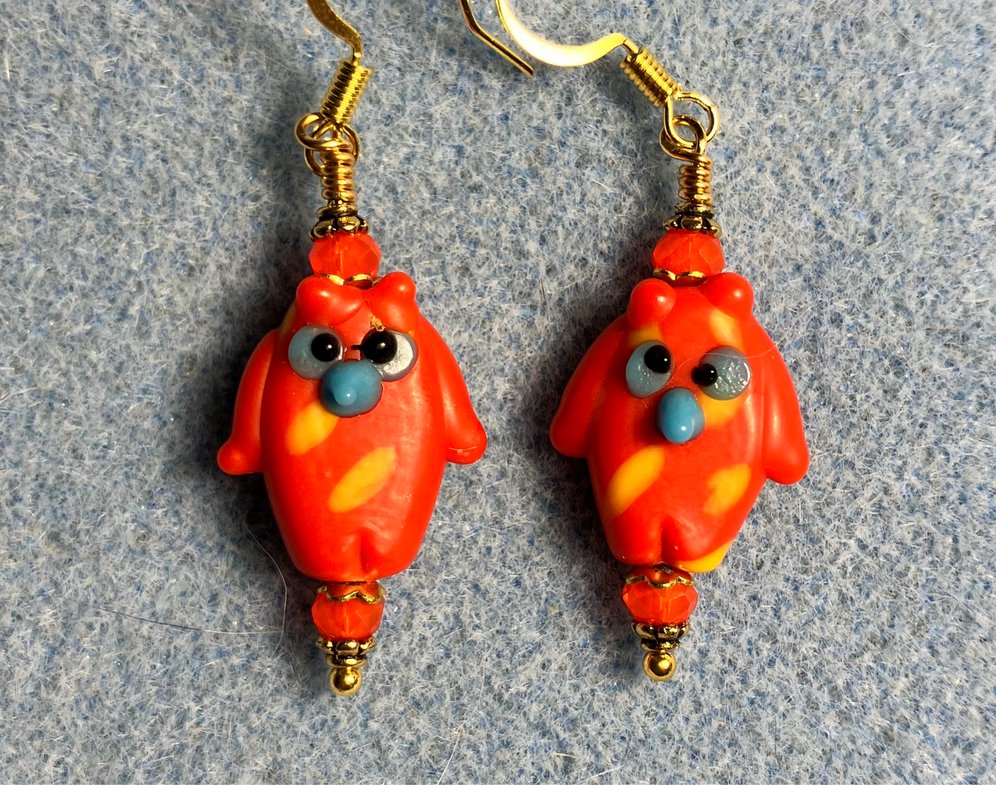 Orange red lamp work owl bead earrings adorned with orange red Chinese crystal beads.