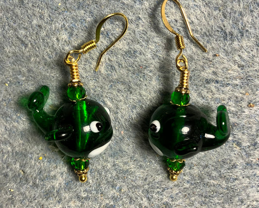 Emerald green lamp work whale bead earrings adorned with emerald green Chinese crystal beads.