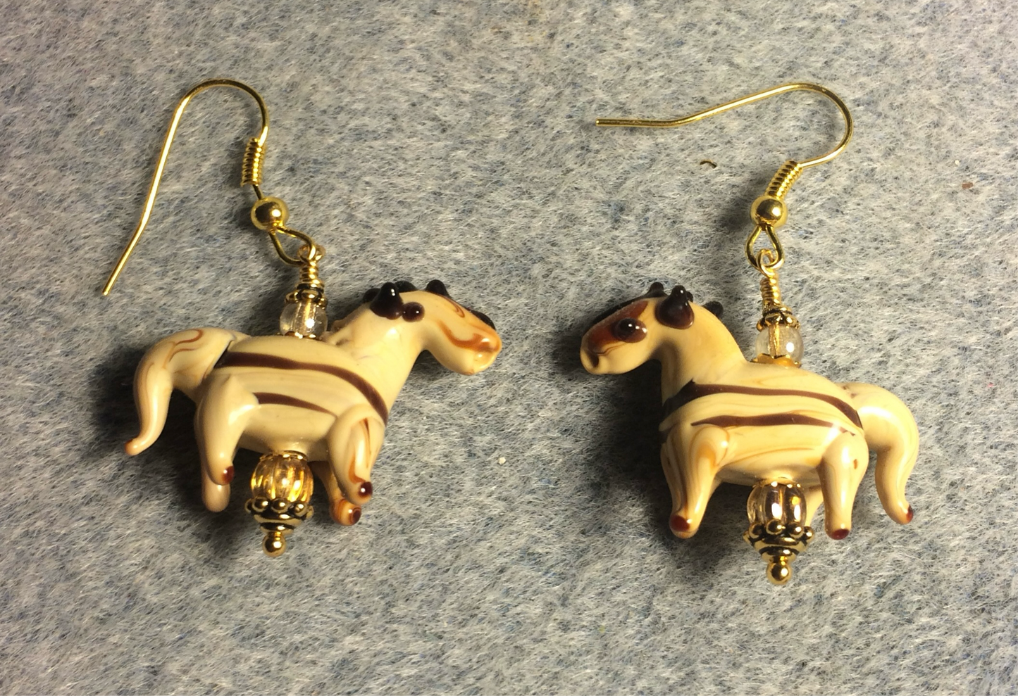 Tan and brown stripes lamp work horse bead earrings adorned with tan Czech glass beads.
