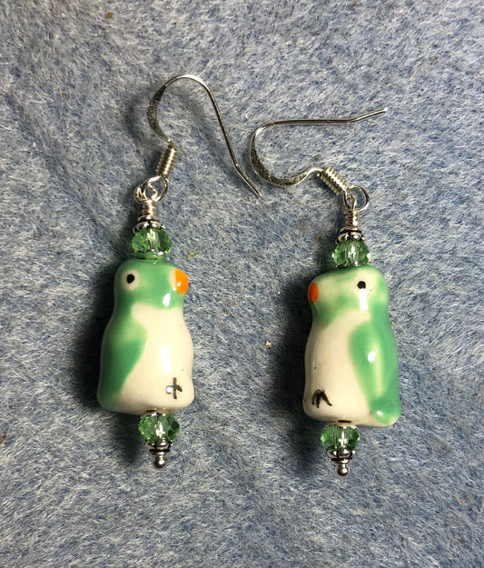 Light green and white ceramic penguin bead earrings adorned with light green Chinese crystal beads.