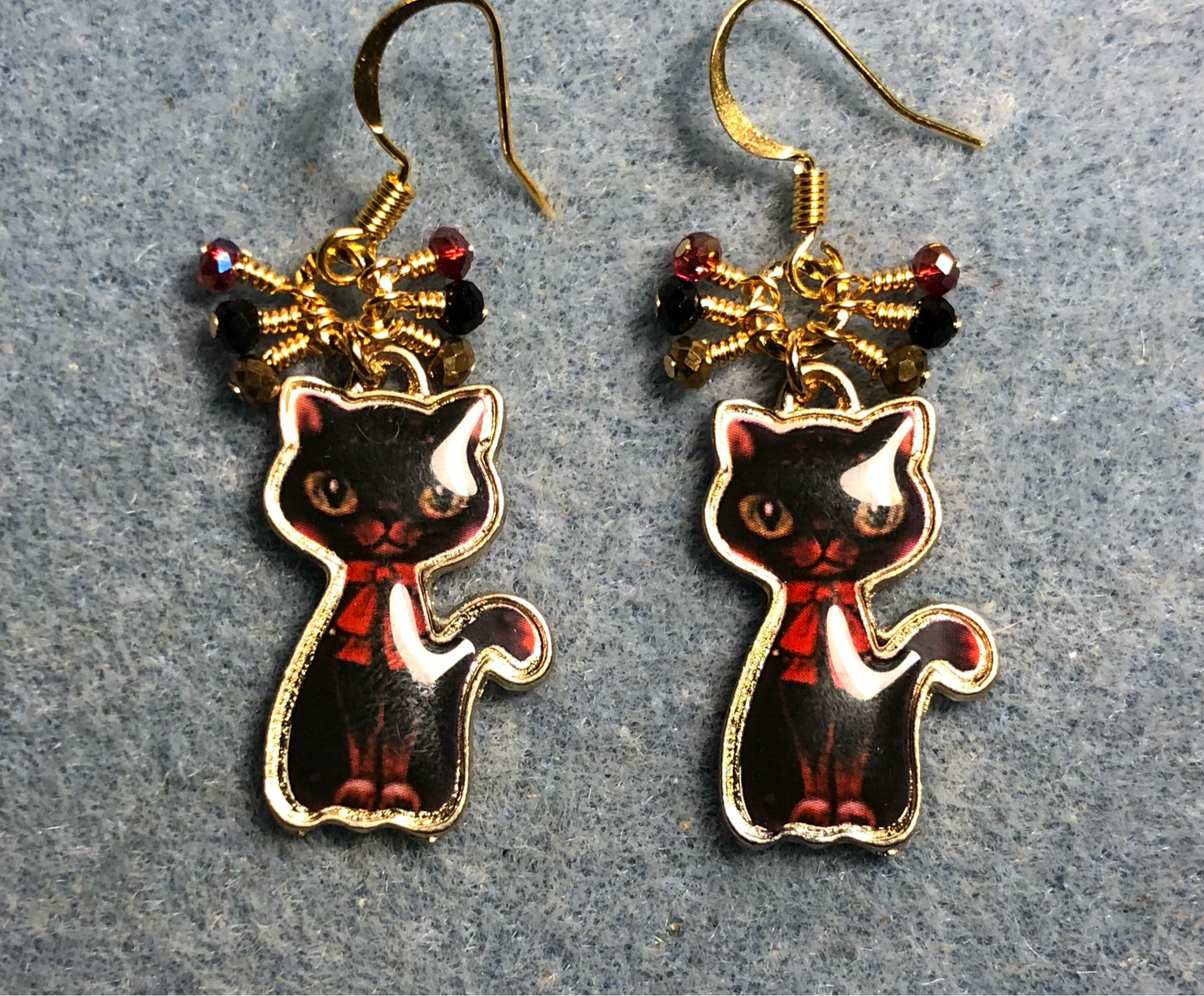 Black and red enamel cat charm earrings adorned with small dangling black, red, and gold Chinese crystal beads.