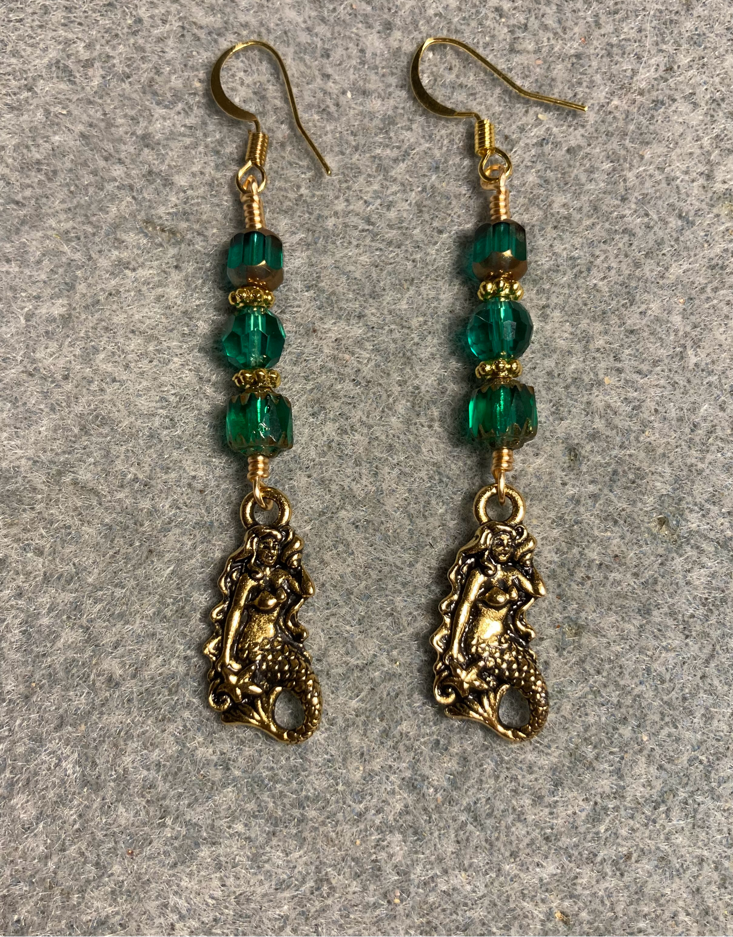 Gold Tierracast mermaid charm earrings adorned with teal Czech glass beads