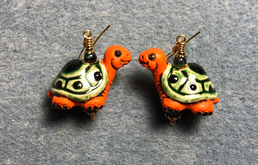 Large dark green and orange ceramic turtle bead earrings adorned with dark green Czech glass beads.