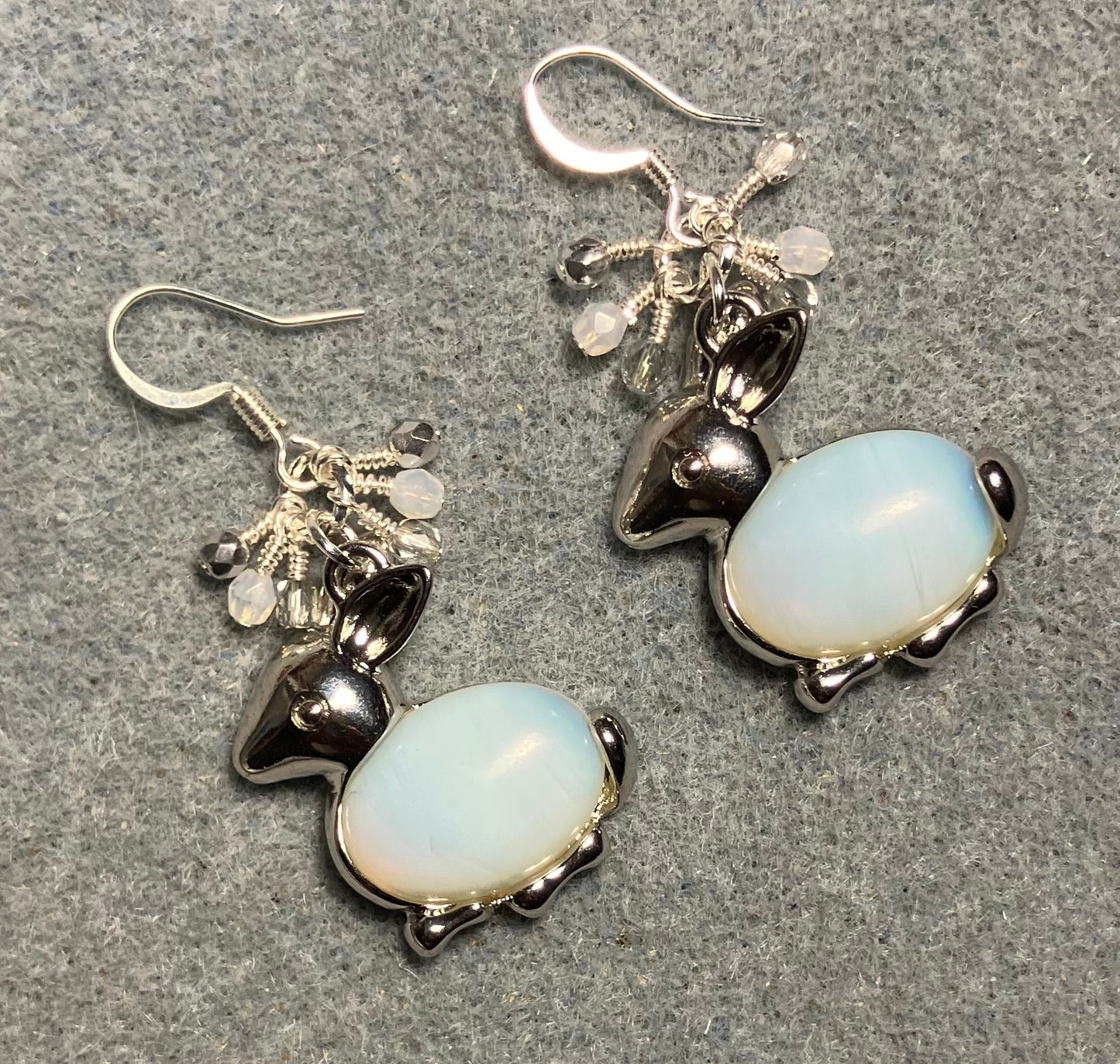 Large silver and opalite gemstone rabbit charm earrings adorned with small dangling white, silver, and clear Czech glass beads.