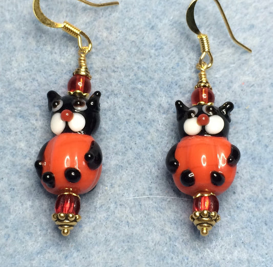 Red and black lamp cat bead earrings adorned with red Czech glass beads.