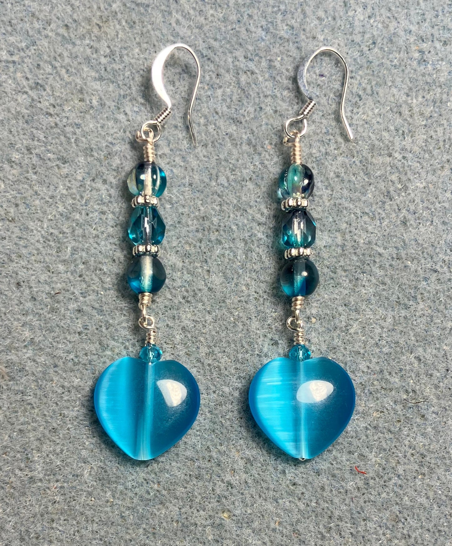 Turquoise fiber optic (cat’s eye) Czech glass heart bead earrings adorned with turquoise Czech glass beads.
