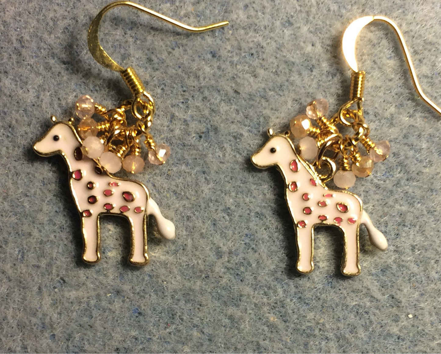 Light pink enamel spotted giraffe charm earrings adorned with tiny dangling pink and peach Chinese crystal beads.