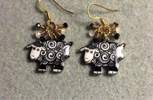 Black and white swirly patterned enamel sheep charm earrings adorned with tiny dangling black, white, and gold Chinese crystal beads.