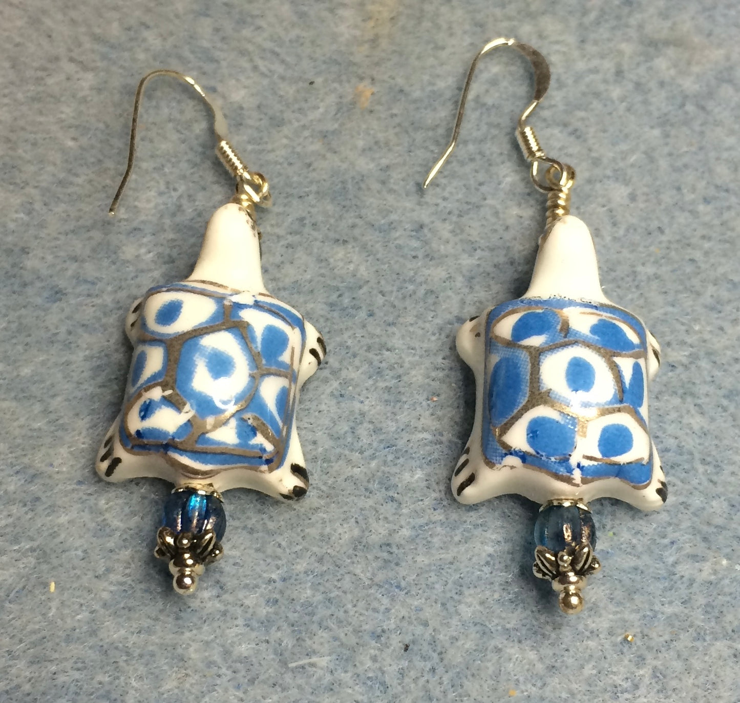 Light blue and white ceramic spotted turtle bead earrings adorned with light blue Czech glass beads.