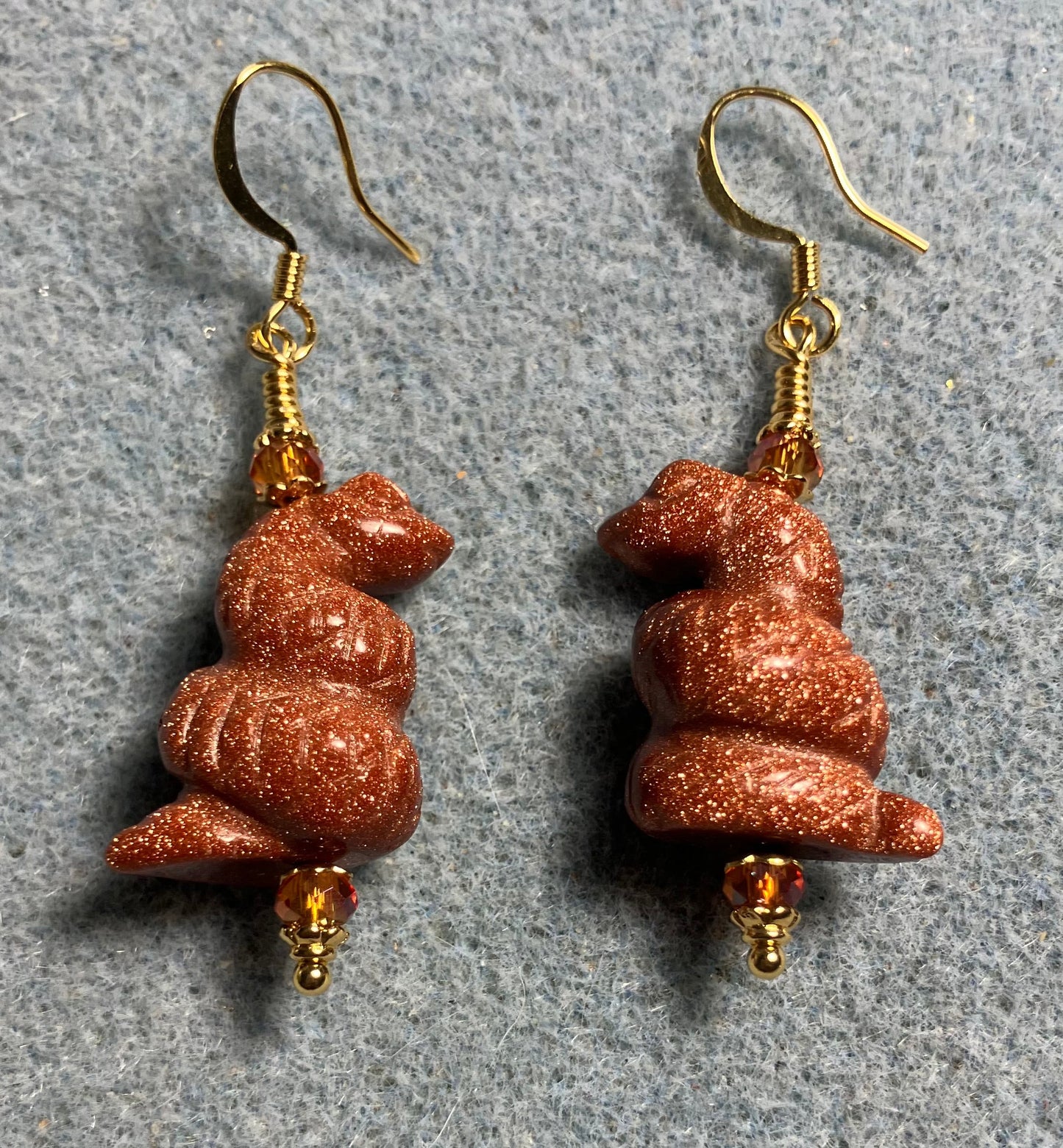 Goldstone gemstone coiled snake bead earrings adorned with orange Chinese crystal beads.
