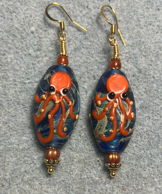 Blue and orange lamp work octopus bead earrings adorned with orange Czech glass beads.