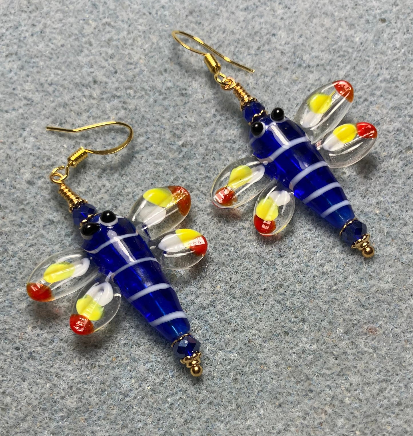 Dark blue, red, and yellow lamp work dragonfly bead earrings adorned with dark blue Chinese crystal beads.