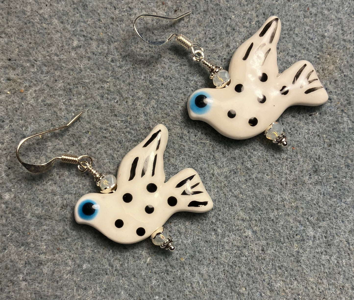 Large white, black, and turquoise ceramic spotted dove bead earrings adorned with white Chinese crystal beads.