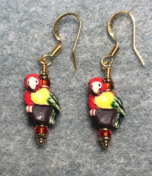 Small red, yellow, and green ceramic parrot bead earrings adorned with red Chinese crystal beads.