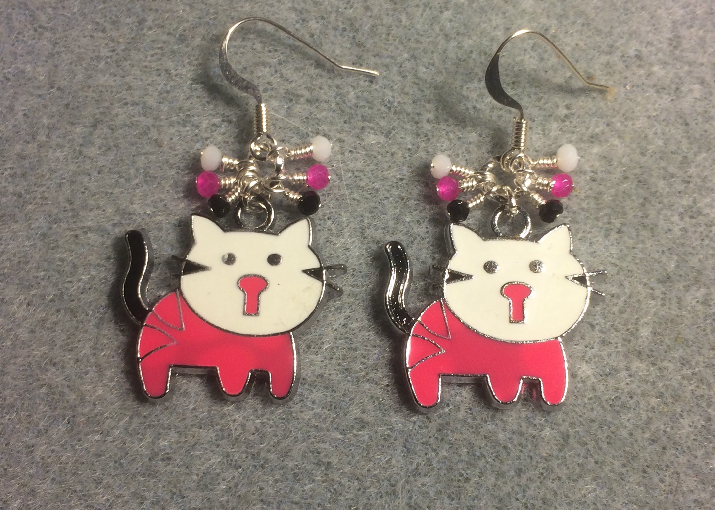 Hot pink, white, and black enamel cat charm earrings adorned with tiny dangling hot pink, white, and black Chinese crystal beads.