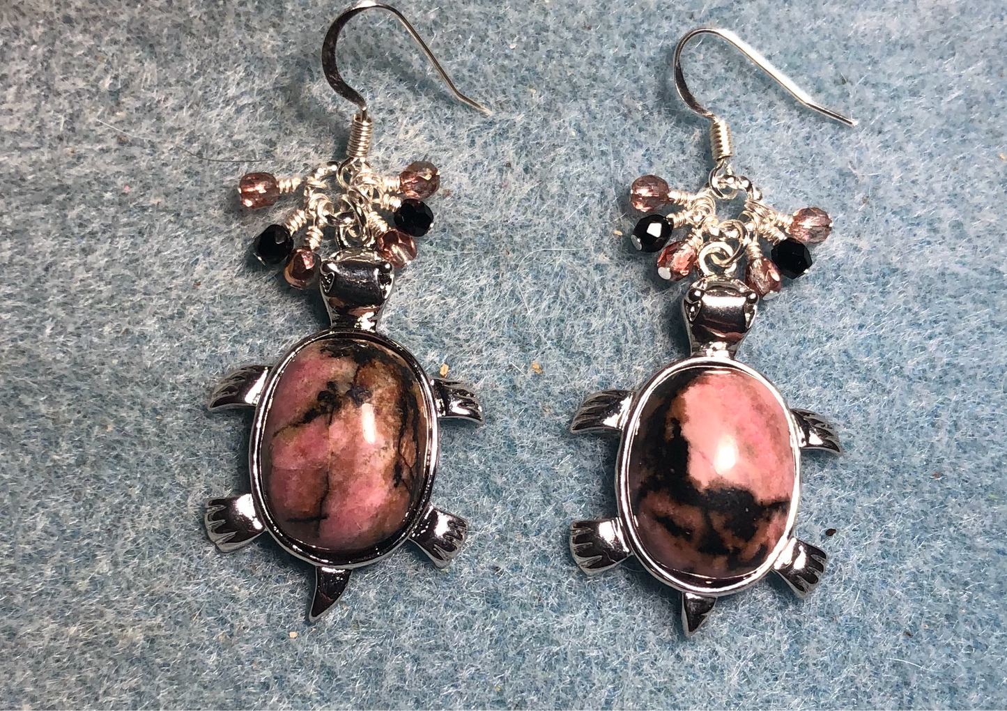 Large silver and pink rhodonite gemstone turtle charm earrings adorned with small dangling rose and black Czech glass beads.