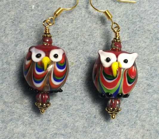 Red and blue lamp work owl bead earrings adorned with red Picasso Czech glass beads.