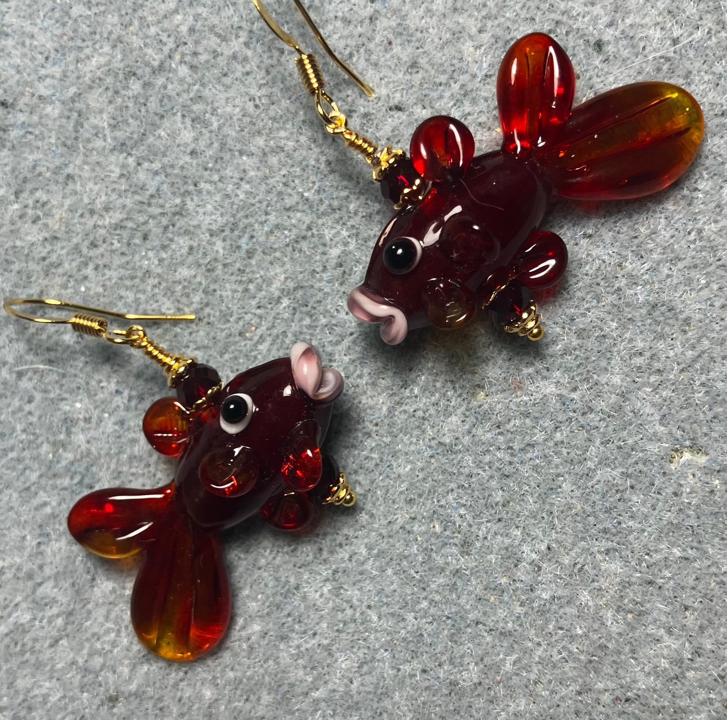 Translucent dark red lamp work fish bead earrings adorned with dark red Chinese crystal beads.