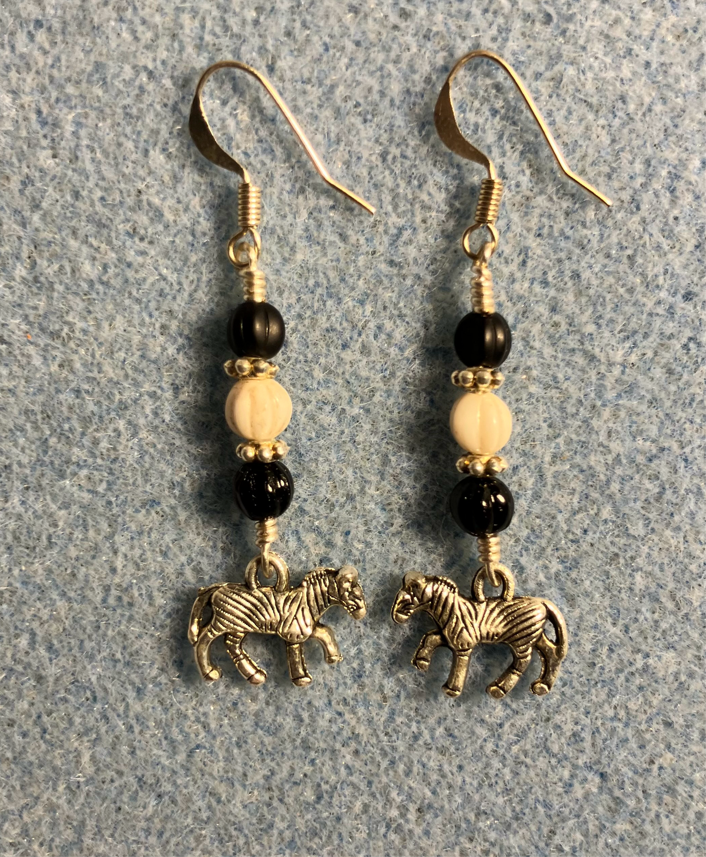 Small silver zebra charm earrings adorned with black and white Czech glass melon beads.