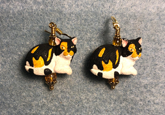 Black, orange, and white ceramic calico cat bead earrings adorned with amber Czech glass beads.