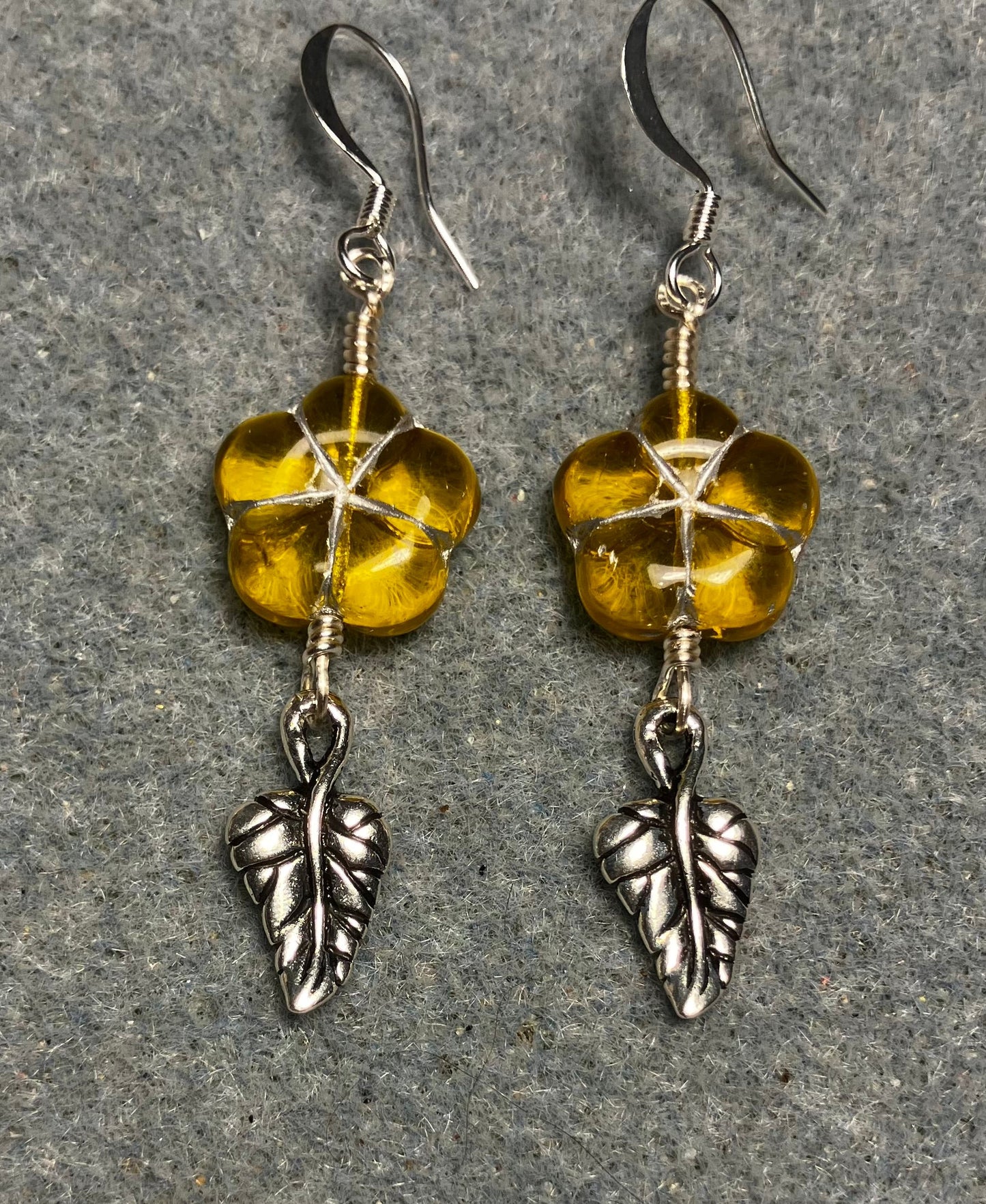 Yellow (with silver inlay) Czech glass puffy flower bead earrings adorned with silver Tierracast leaf charms.