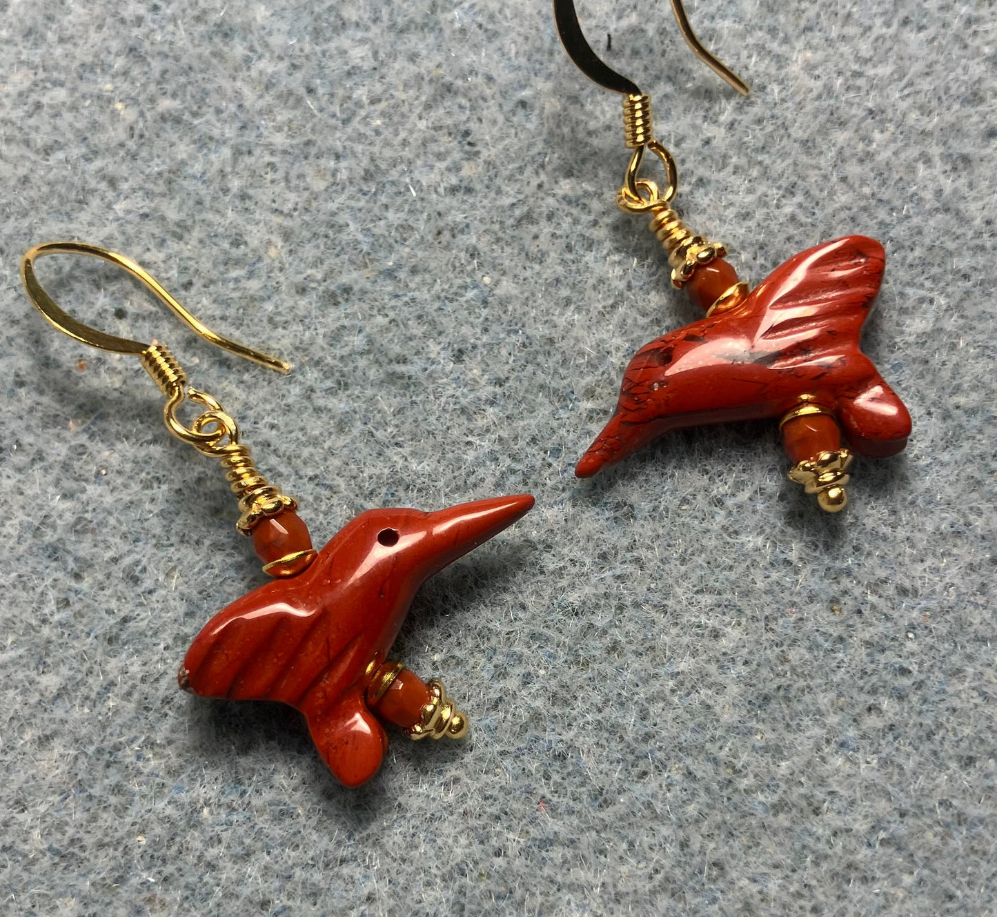 Small poppy jasper gemstone hummingbird bead earrings adorned with small orange Czech glass beads.