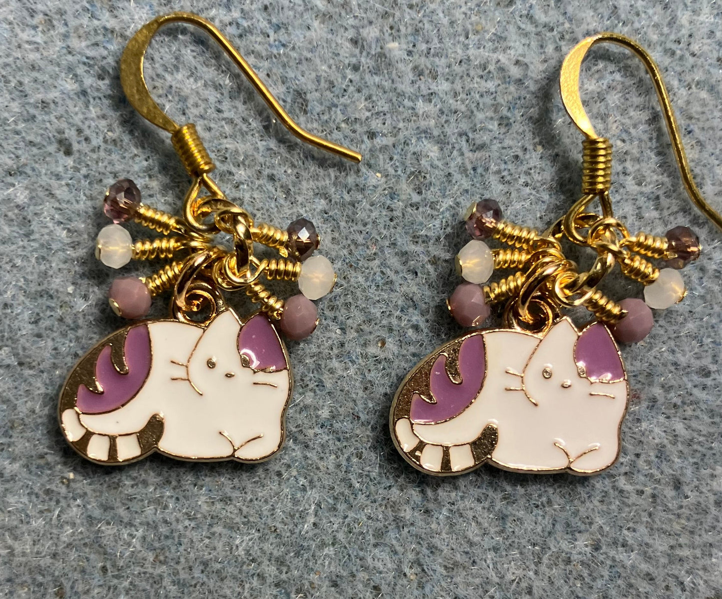 Small violet and white enamel cat charm earrings adorned with tiny dangling violet and white Chinese crystal beads.