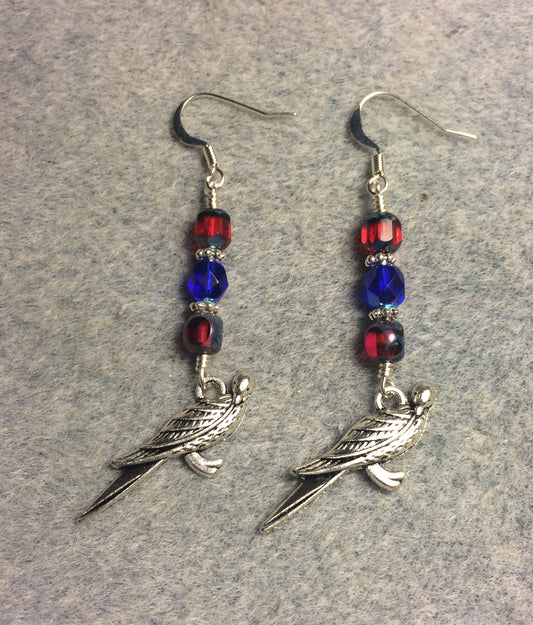 Silver parrot charm earrings adorned with red and blue Czech glass beads