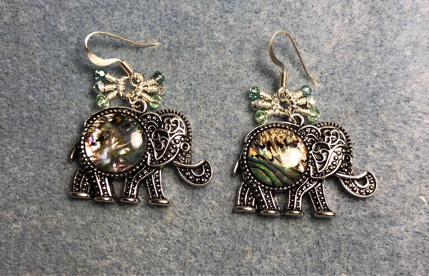 Silver and abalone elephant charm earrings adorned with tiny dangling silver and green Chinese crystal beads.