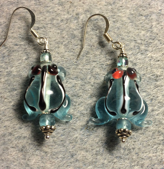 Translucent light turquoise lamp work striped frog bead earrings adorned with light turquoise Czech glass beads.