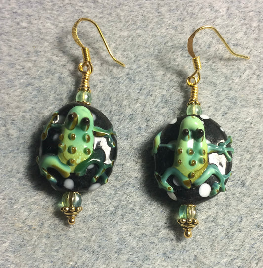 Black and green lamp work frog bead earrings adorned with green Czech glass beads.