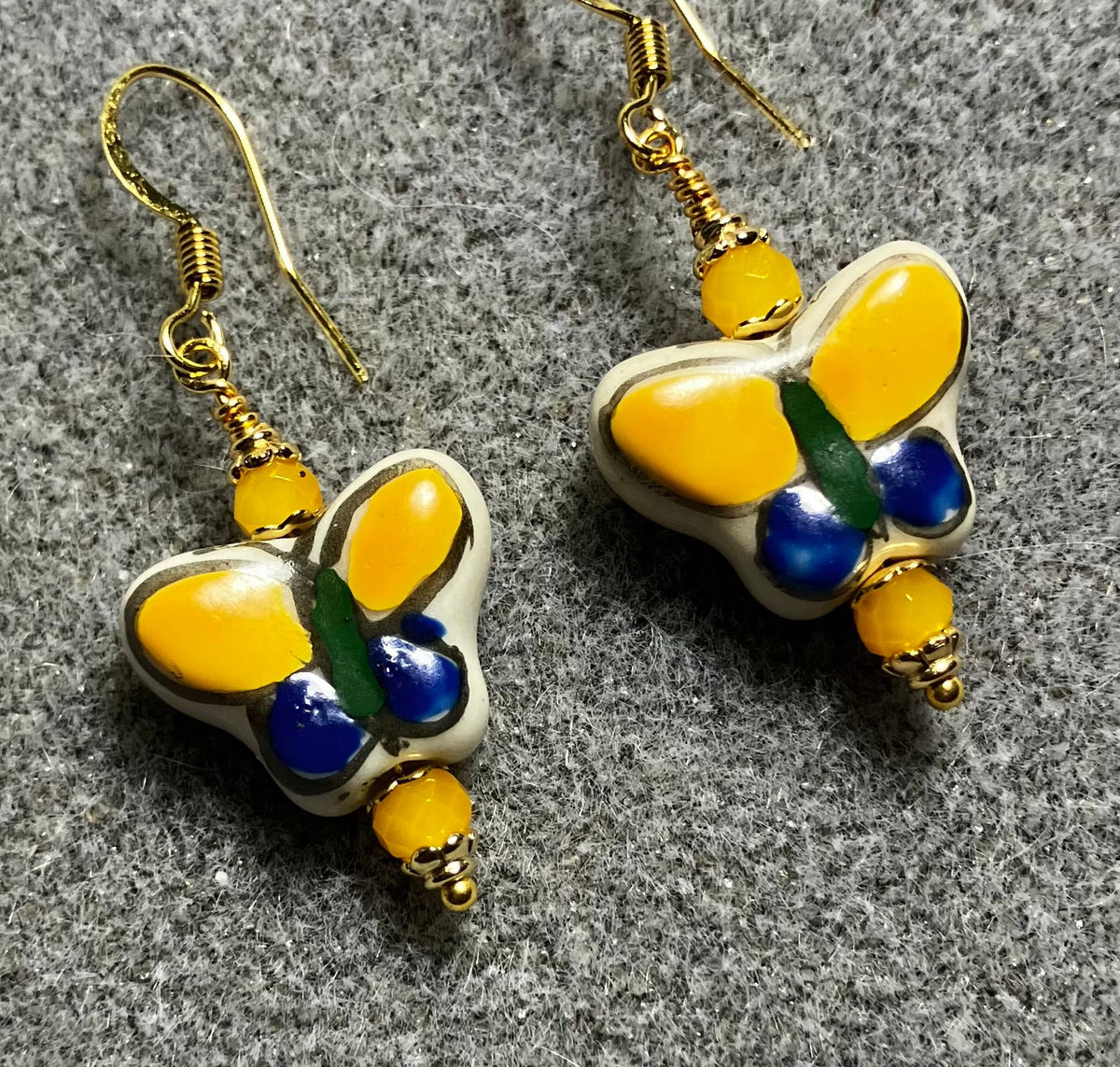 Dark blue and yellow ceramic butterfly bead earrings adorned with yellow Chinese crystal beads.
