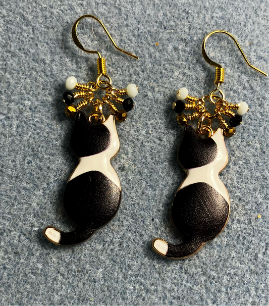 Black and white enamel cat charm earrings adorned with tiny dangling gold, black, and white Chinese crystal beads.
